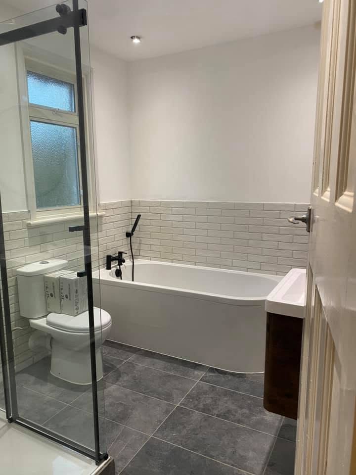 Family bathroom with metro tiling, black brassware and slate floor